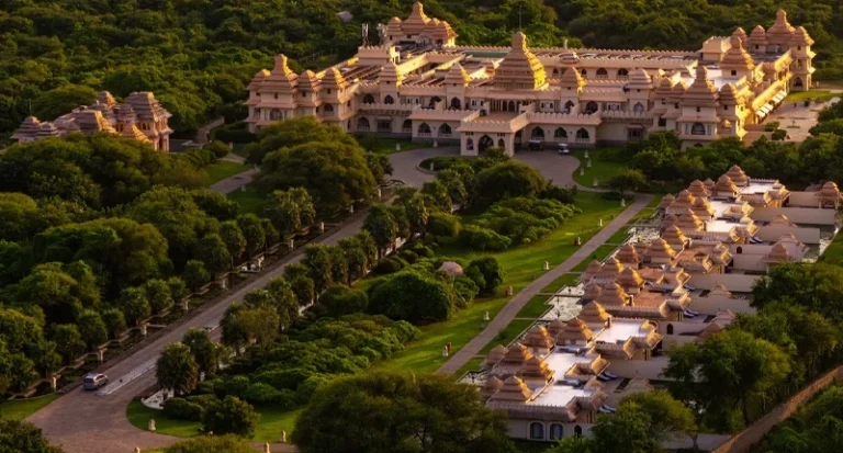 Aerial view of grand luxury heritage palace resort nestled in lush green fores