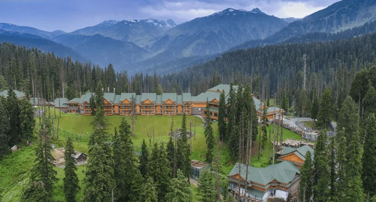 Aerial view of a luxury mountain resort nestled in a pine forest valley