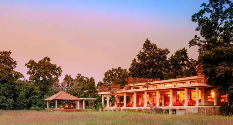 Luxury safari lodge villa illuminated at sunset in a wilderness reserve
