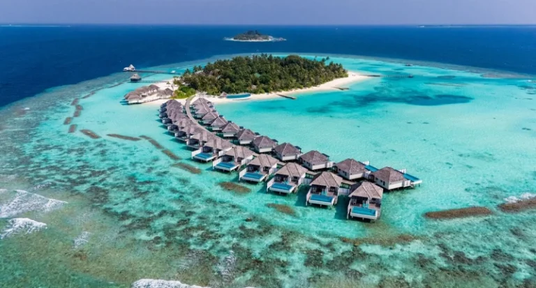 Aerial view of luxury overwater bungalows extending into turquoise ocean lagoon in the Maldives